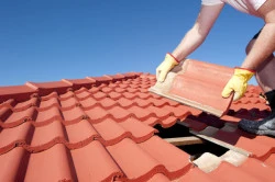 Artisan couvreur pour travaux de réparation sur toiture d'immeuble en centre-ville  